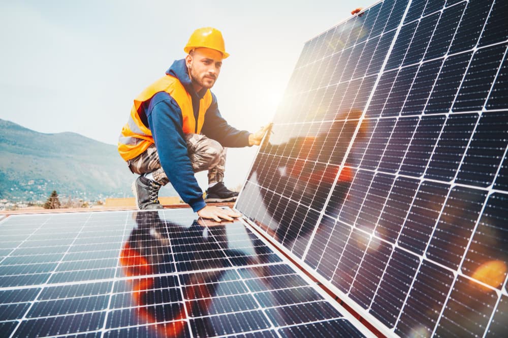 ouvrier installe des panneaux solaires